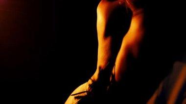 Deri bir kırbaçla vurulan bir kızın arka silueti. Erkek ellerinde BDSM kırbacı. Karanlık bir odada kırbaç darbeleri..