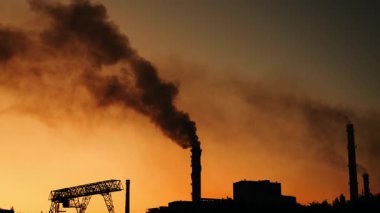 Endüstriyel bir bacadan yayılan zehirli kara duman bulutları. Endüstriyel hava ve atmosfer kirliliği. Küresel ısınma çevresel hasar.