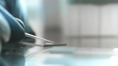 Bir genetik laboratuvarı araştırmacısı bir pipetle numune bırakıyor. Modern bir laboratuvarda DNA üzerinde çalışma kavramı. Bilim ve tıp. Genetik Çalışmalar İçin Laboratuar Deneyleri.