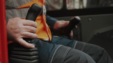 A close-up of the hands of a worker operating a joystick. Controls of heavy construction equipment. The operator controls an excavator.