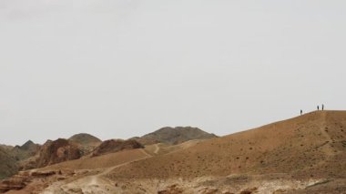 A group of backpackers on a mountaintop overlooking the canyon. Hikers on a hike in the canyon. Three hikers enjoying the views.