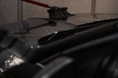 Genç bir adam araba yıkamada yüksek basınçlı suyla araba yıkar. Araba yıkama, yüksek basınçlı su basıncı, araba yıkama, araba yıkama.