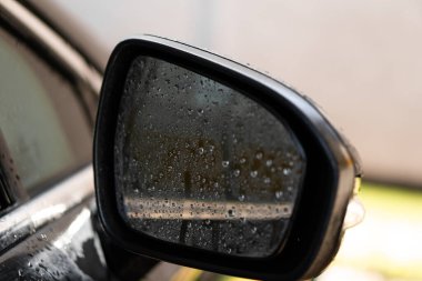 Araba aynası yağmur damlaları olan bir arabada