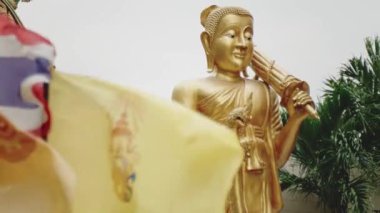 Altın Buda heykeli ve Tayland Kraliyet Bayrağı rüzgarda hareket ediyor