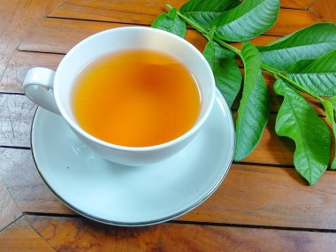 Kaynamış guava yapraklarından yapılan bitkisel içecek bir bardakta servis edilir.