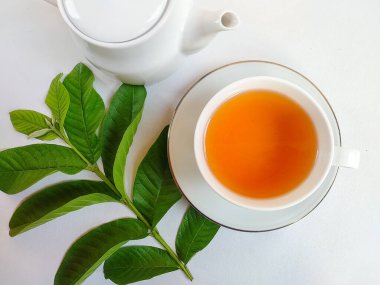 Kaynamış guava yapraklarından yapılan bitkisel içecek bir bardakta servis edilir.