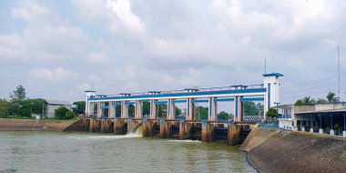 Tangerang City, Endonezya 'daki modern su kapısı yapısı, bulutlu gökyüzü altında sulama ve sel yönetimi için kullanılan nehir akışını kontrol eden mavi ve beyaz tasarımı ile