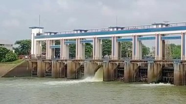 Tangerang City, Endonezya 'daki modern su kapısı yapısı, bulutlu gökyüzü altında sulama ve sel yönetimi için kullanılan nehir akışını kontrol eden mavi ve beyaz tasarımı ile