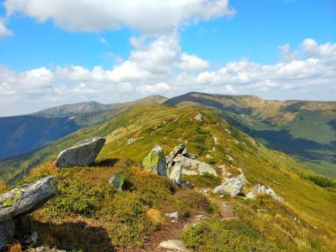 Dağ sırasının manzarası ve parlak bir yaz gününde kayalar. Sıcak bir yaz gününde Ukrayna Karpatları 'nda güzel bir kayalık dağ sırası boyunca yürüyüş yapmak.