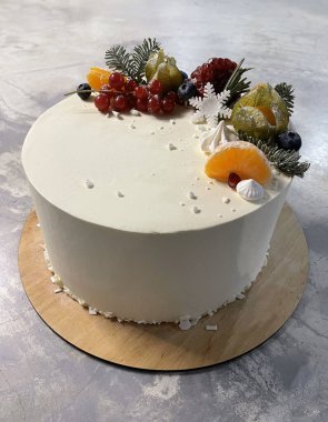 Çeşit çeşit böğürtlen ve taze meyvelerle süslenmiş beyaz pasta.