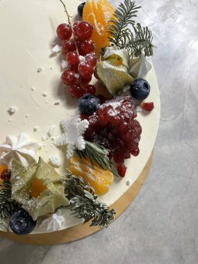 Beyaz pastadaki renkli meyve ve böğürtlen aksanları