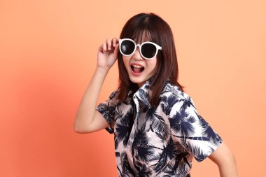 Mutlu SONGKRAN GÜNÜ. Turuncu arka planda el ele tutuşan neşeli, sevimli, genç Asyalı kadın. Tayland Yeni Yıl Günü.