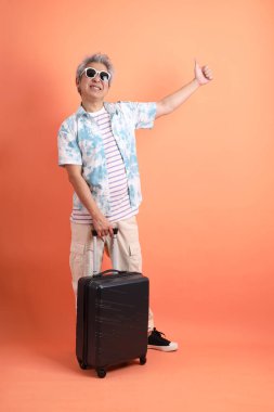 Mutlu SONGKRAN GÜNÜ. Turuncu arka planda el ele tutuşan Asya 'lı son sınıf öğrencisi. Songkran festivali. Tayland Yeni Yıl Günü.