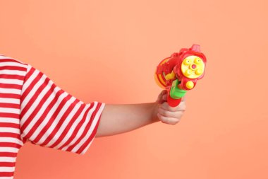 Turuncu arka planda plastik su tabancası var. Songkran festivali. Tayland Yeni Yıl Günü.