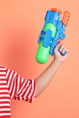 Turuncu arka planda plastik su tabancası var. Songkran festivali. Tayland Yeni Yıl Günü.