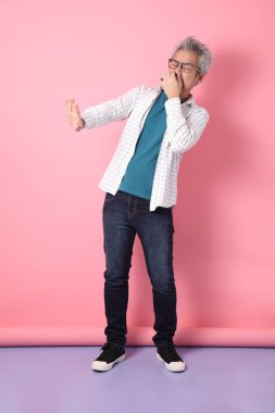 Pembe arka planda izole edilmiş hastalıklı davranışları olan son sınıf Asyalı bir adam. Sevgililer Günü