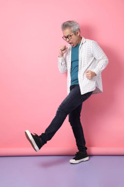 Pembe arka planda izole edilmiş hastalıklı davranışları olan son sınıf Asyalı bir adam. Sevgililer Günü