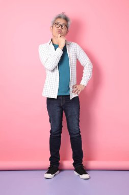 Pembe arka planda soyutlanmış bir düşünce jesti olan son sınıf Asyalı bir adam. Sevgililer Günü