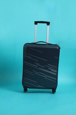 izole mavi zemin üzerine siyah bavul.