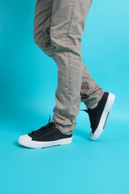 Erkek eli bağlayan spor ayakkabı bağı, mavi arka planda izole edilmiş.. 