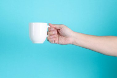 Mavi arka planda izole edilmiş bir fincan.