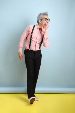 Mavi arka planda izole edilmiş kırmızı fiyonklu Asyalı son sınıf öğrencisi. Sevgililer Günü