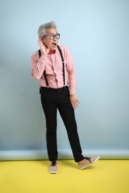 Mavi arka planda izole edilmiş kırmızı fiyonklu Asyalı son sınıf öğrencisi. Sevgililer Günü