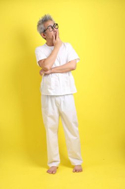 Çin Vejetaryen Festivali. Sarı arka planda izole edilmiş beyaz giysili kıdemli bir adam. Dokuz imparator Tanrı, J festivali.