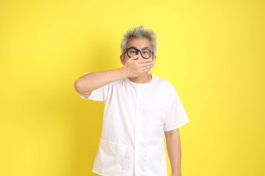 Çin Vejetaryen Festivali. Beyaz giysili, ağzı kapalı, sarı arka planda izole edilmiş sessiz bir jest. Dokuz imparator Tanrı, J festivali.