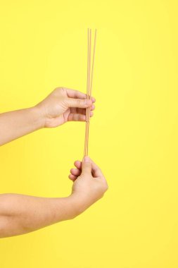 Çin Vejetaryen Festivali. Sarı arka planda izole edilmiş tütsü çubuklarını tutan beyaz giysili yaşlı adam. Dokuz imparator Tanrı, J festivali.