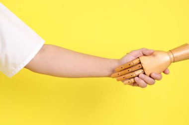 Sarı arka planda birden fazla pozu olan bir manken eli. Sembol, Kukla.