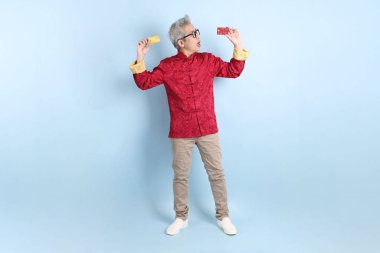 Yeni Çin yılın kutlu olsun. Asya 'nın enerjik kıdemli adamı geleneksel kırmızı Cheongsam Qipao ya da Changshan elbisesi giyiyor..