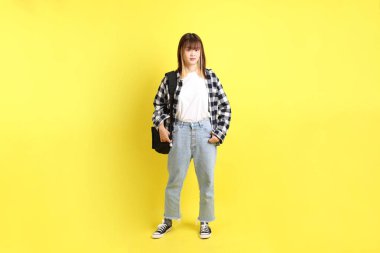 Okul çantasıyla ayakta duran ekose gömlek giyen bir üniversite öğrencisi. Eğitim, yurtdışında eğitim, Z jenerasyonu, E-öğrenim. Ergen.