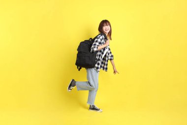 Okul çantasıyla ayakta duran ekose gömlek giyen bir üniversite öğrencisi. Eğitim, yurtdışında eğitim, Z jenerasyonu, E-öğrenim. Ergen.