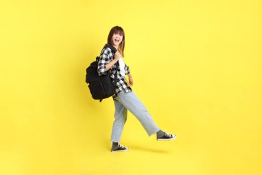 Okul çantasıyla ayakta duran ekose gömlek giyen bir üniversite öğrencisi. Eğitim, yurtdışında eğitim, Z jenerasyonu, E-öğrenim. Ergen.