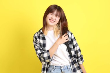 Okul çantasıyla ayakta duran ekose gömlek giyen bir üniversite öğrencisi. Eğitim, yurtdışında eğitim, Z jenerasyonu, E-öğrenim. Ergen.