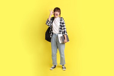 Okul çantası ve kitap taşırken ekose gömlek giyen bir üniversite öğrencisi. Eğitim, yurtdışında eğitim, Z jenerasyonu, E-öğrenim. Ergen.