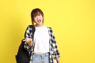 Okul çantası ve kitap taşırken ekoseli gömlek giyen bir üniversite öğrencisi. Eğitim, yurtdışında eğitim, Z jenerasyonu, E-öğrenim. Ergen.