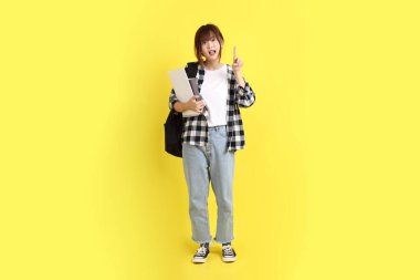 Okul çantası ve kitap taşırken ekoseli gömlek giyen bir üniversite öğrencisi. Eğitim, yurtdışında eğitim, Z jenerasyonu, E-öğrenim. Ergen.