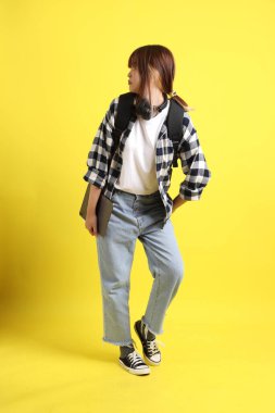 Ekose gömlek giyen Asyalı kız öğrenci okul çantası, ayakta durma ve tablet tutma hareketi taşıyor. Yurtdışında okumak, Z Geni, E-öğrenimi.