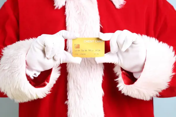 Mutlu Noeller, neşeli son sınıf öğrencisi kış tatilini kutluyor. Sarı ve mavi arka planda Noel Baba kostümü giyiyor. Mutlu Noeller.