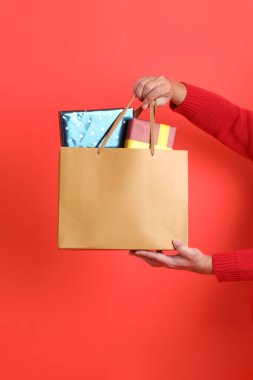 Kırmızı bir hırka giyen, kırmızı bir arka planda izole edilmiş bir el. Mutlu Noeller..