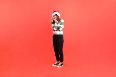 Kırmızı arka planda, Noel Baba şapkalı ve diş ağrısı olan Asyalı bir kadın. Noel Baba! Noel Baba!.