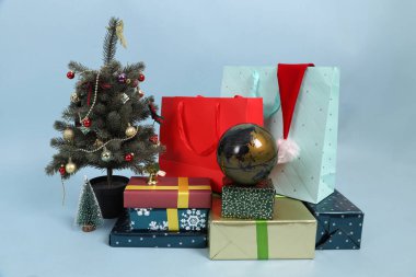 Noel, yeni yıl hediye kutuları, parlak ambalajlı hediyeler, mavi arka planda ipek kurdeleler..