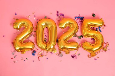 Yeni yılınız kutlu olsun. 2025 numaralı parlak altın balonlar. İki bin yirmi beş yeni yıl balonu pembe bir zemin oluşturdu. Yılan Yılı