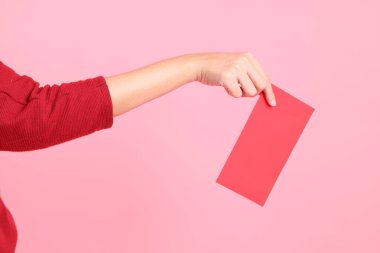 Mutlu Çin Yeni Yılları, pembe arka planda Çin kırmızı zarfları tutan kırmızı tişörtlü Asyalı bir kadının eli.. 