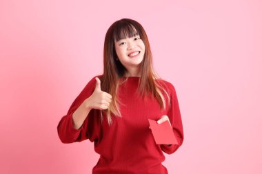 Mutlu Çin Yeni Yılı, pembe arka planda Çin kırmızısı zarflar tutan kırmızı tişörtlü Asyalı bir kadın. Gen Z