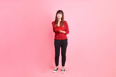 Mutlu Çin Yeni Yılı, kırmızı tişörtlü Asyalı genç bir kadın. Elinde Çin kırmızısı zarflar ve pembe arka planda izole edilmiş bir düşünce var. Gen Z