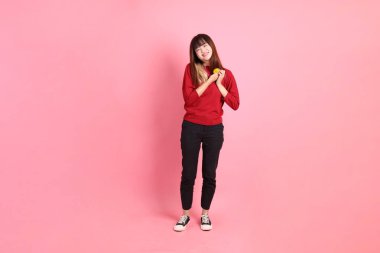 Mutlu Çin Yeni Yılı, pembe arka planda, elinde Mandalina ya da Portakal tutan kırmızı günlük Asyalı kadın tişörtü. Gen Z