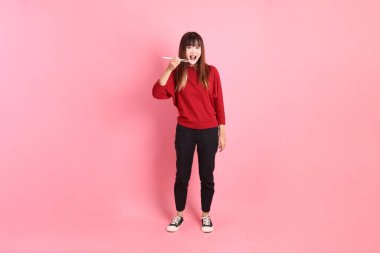 Mutlu Çin Yeni Yılı, pembe arka planda izole edilmiş plastik çubuklarla el ele tutuşan kırmızı günlük Asyalı kadın tişörtü. Gen Z